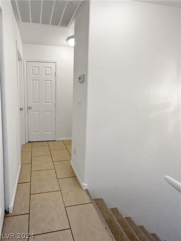 hall featuring light tile patterned floors