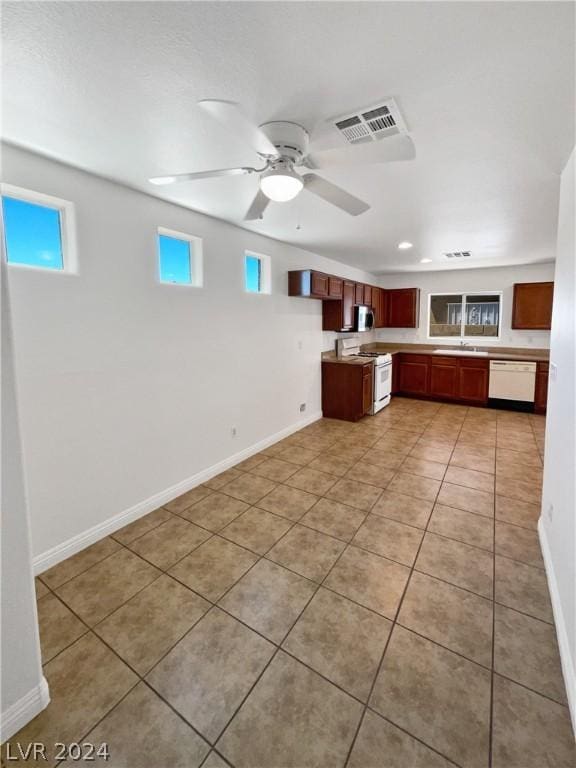 kitchen with light tile patterned flooring, white appliances, and ceiling fan