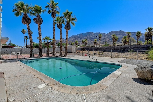 view of swimming pool featuring a mountain view and a patio area