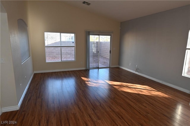 spare room with vaulted ceiling and dark hardwood / wood-style flooring