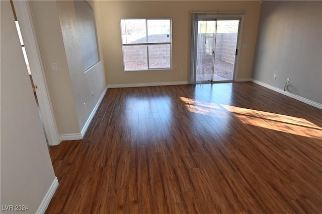 unfurnished room with dark hardwood / wood-style flooring