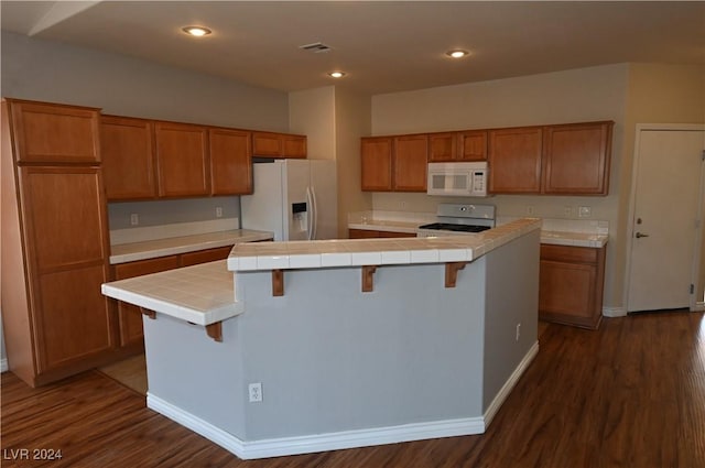 kitchen with white appliances, tile counters, and a kitchen island