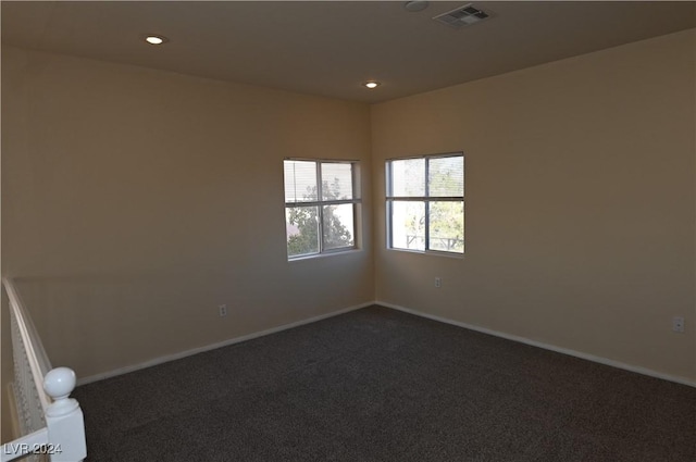 unfurnished room with dark colored carpet