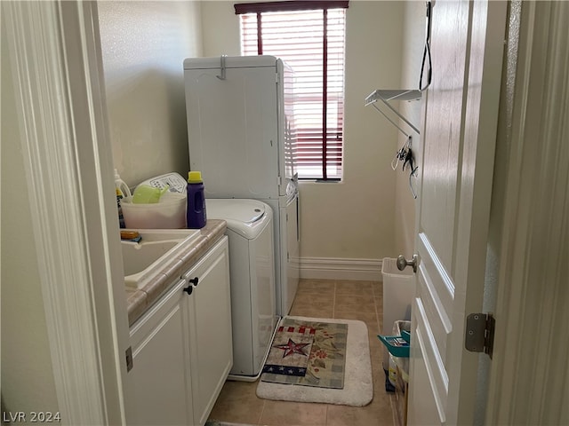 washroom with washer / dryer, cabinets, and light tile floors