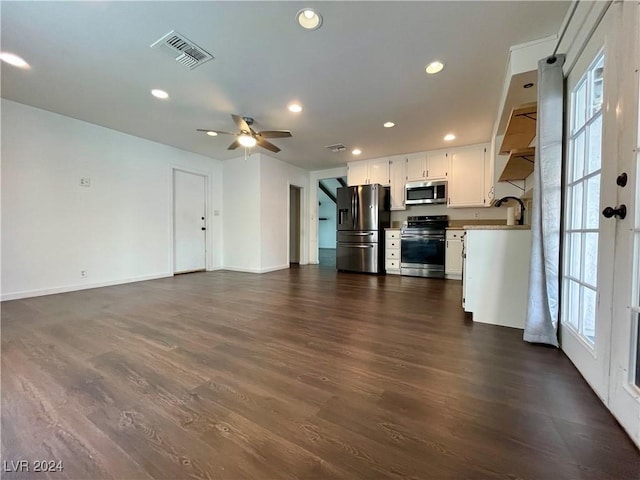 unfurnished living room featuring ceiling fan, sink, and dark wood-type flooring