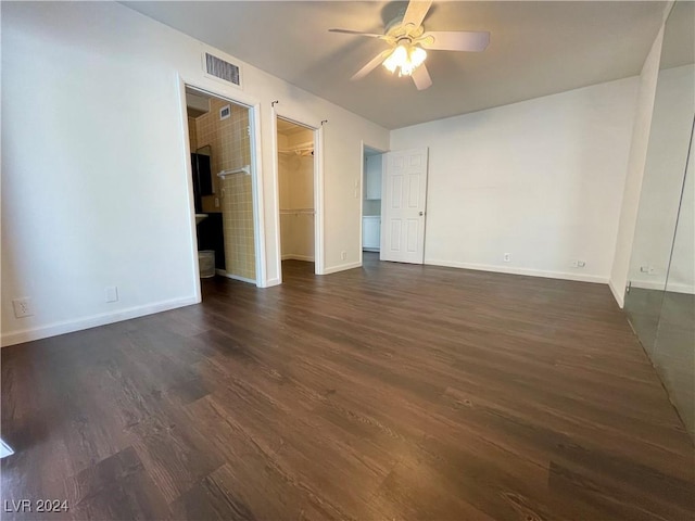 unfurnished bedroom featuring ceiling fan, dark hardwood / wood-style flooring, a spacious closet, and a closet