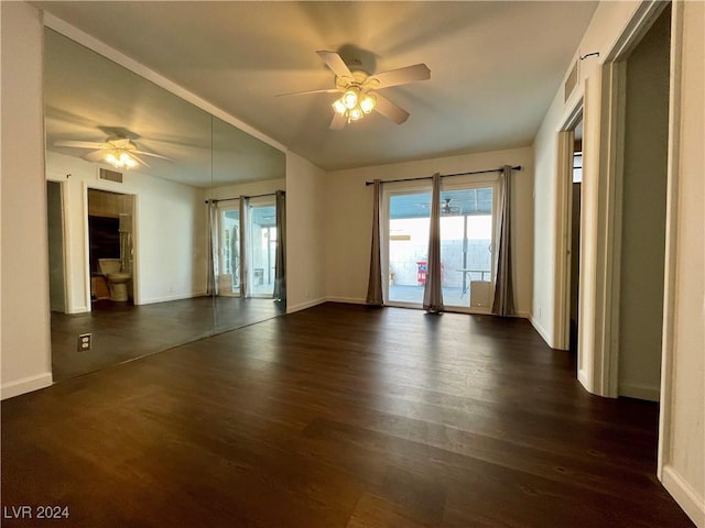 empty room featuring ceiling fan and dark hardwood / wood-style flooring