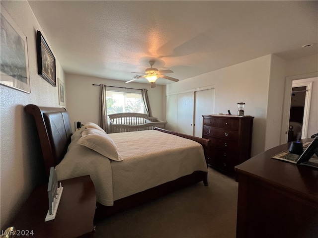 bedroom featuring dark colored carpet, a closet, a textured ceiling, and ceiling fan