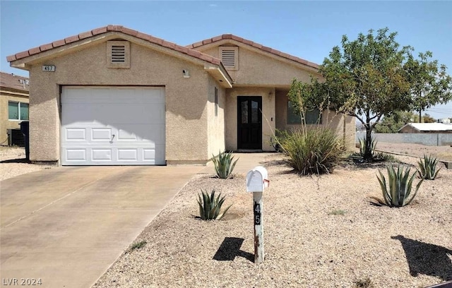 view of front of property featuring a garage and central air condition unit