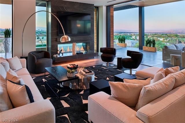 living room featuring a fireplace, a wall of windows, and a wealth of natural light