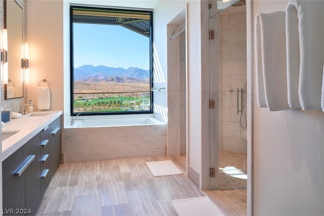 bathroom featuring plus walk in shower, double vanity, and a mountain view