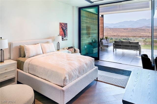 bedroom with a mountain view, hardwood / wood-style floors, and floor to ceiling windows