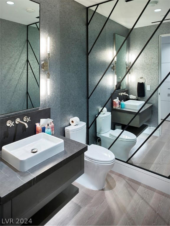 bathroom featuring toilet, hardwood / wood-style floors, and vanity