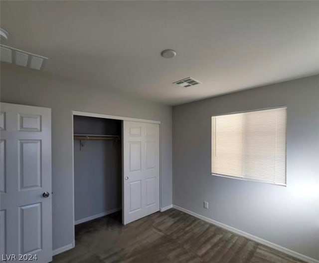 unfurnished bedroom with a closet and dark hardwood / wood-style flooring