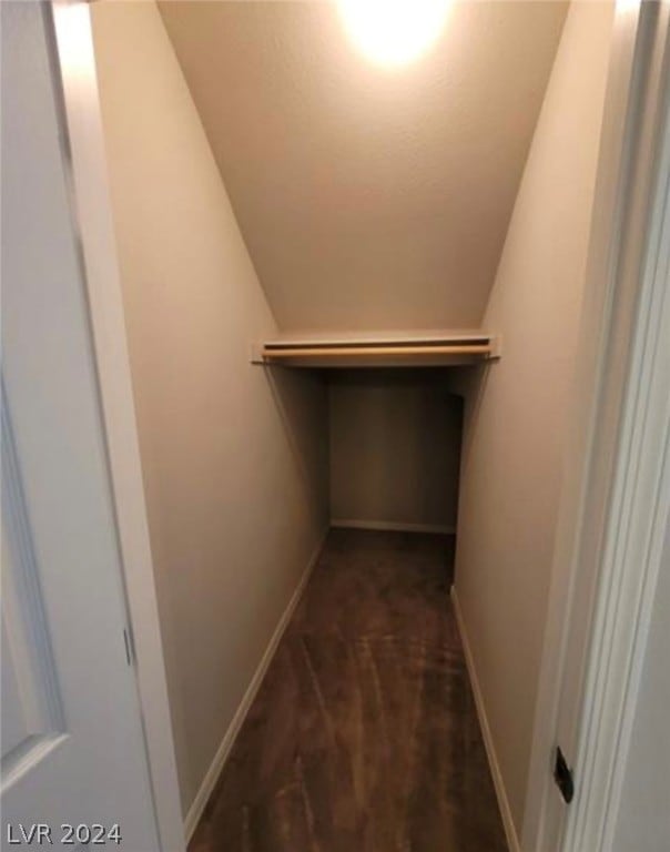 walk in closet featuring dark carpet