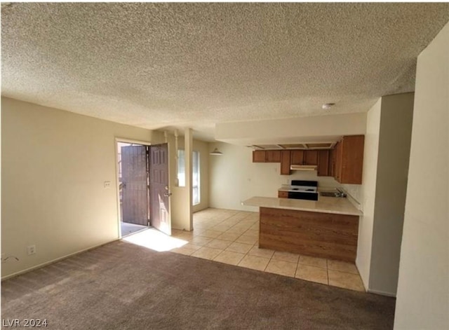 4300 N Lamont St Unit 232, Las Vegas, NV 89115 - kitchen featuring a textured ceiling, range, light colored carpet, and kitchen peninsula