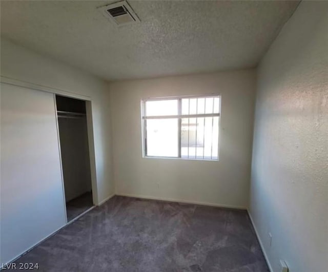 4300 N Lamont St Unit 232, Las Vegas, NV 89115 - unfurnished bedroom featuring a closet, a textured ceiling, and dark colored carpet