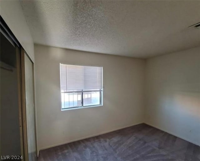4300 N Lamont St Unit 232, Las Vegas, NV 89115 - unfurnished bedroom with dark carpet, a textured ceiling, and a closet