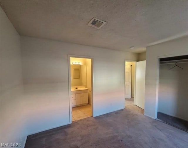 4300 N Lamont St Unit 232, Las Vegas, NV 89115 - unfurnished bedroom with a textured ceiling, light carpet, sink, a closet, and ensuite bathroom