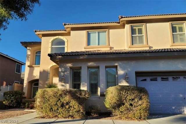 mediterranean / spanish-style house with a garage