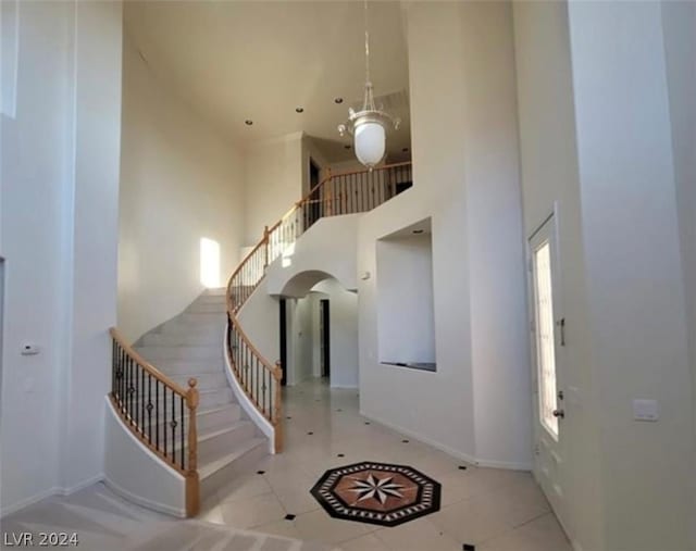 tiled entrance foyer featuring a high ceiling