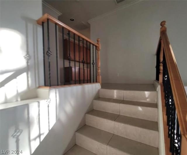 stairway featuring tile patterned flooring and ornamental molding