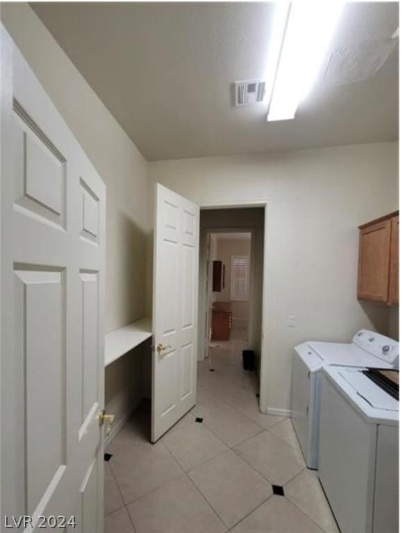 laundry area featuring cabinets, light tile patterned flooring, and separate washer and dryer