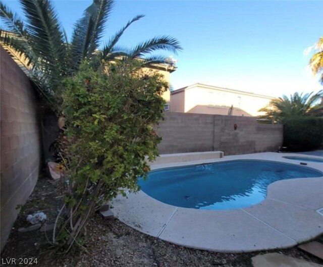 view of pool at dusk