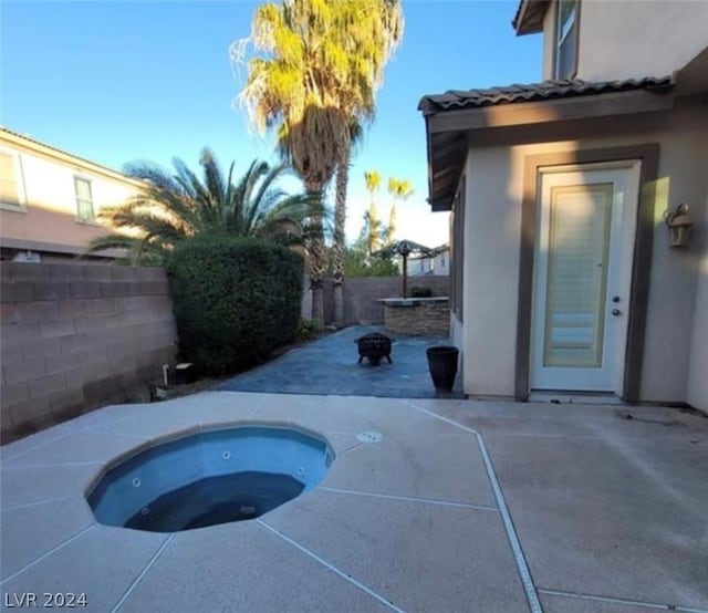 view of pool featuring an in ground hot tub, an outdoor fire pit, and a patio