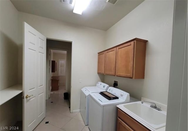 clothes washing area featuring independent washer and dryer, cabinets, light tile patterned flooring, and sink