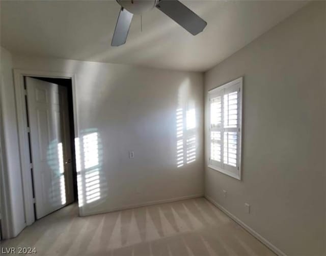 empty room with light colored carpet and ceiling fan