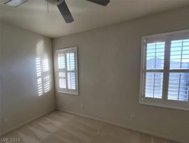 carpeted spare room with ceiling fan