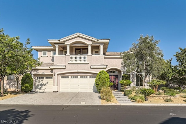 mediterranean / spanish house featuring concrete driveway, an attached garage, a balcony, and stucco siding