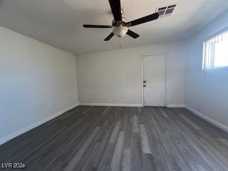 empty room with dark wood-type flooring and ceiling fan