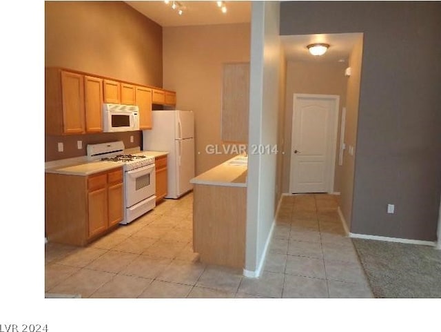 kitchen featuring white appliances, light countertops, baseboards, and light tile patterned floors