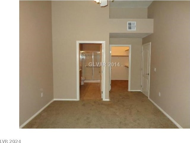 unfurnished bedroom with visible vents, baseboards, a closet, a walk in closet, and carpet flooring