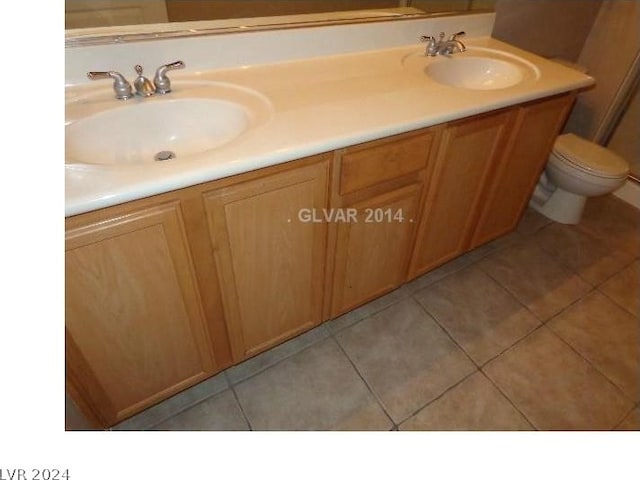 bathroom featuring tile flooring, toilet, and dual bowl vanity