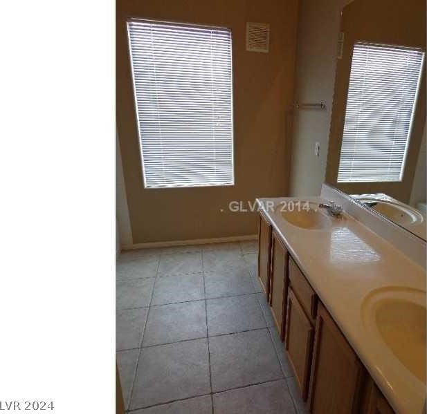 bathroom with tile flooring and dual vanity