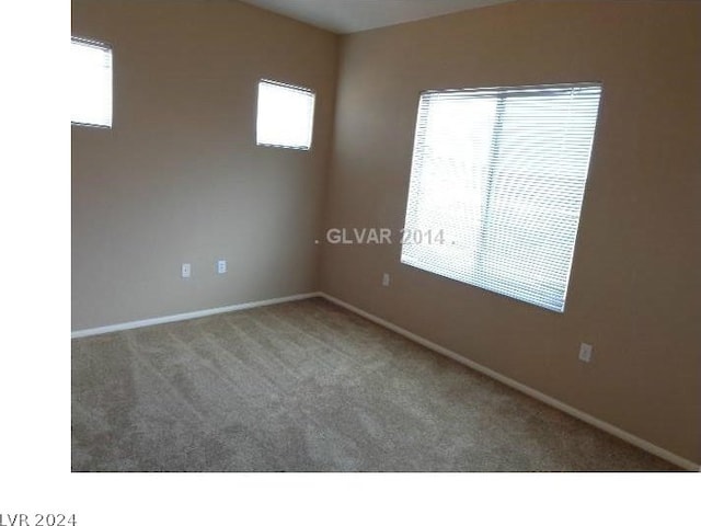 carpeted empty room with baseboards