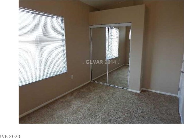 unfurnished bedroom with a closet and dark carpet