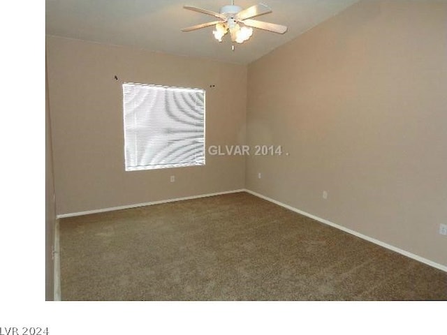 carpeted empty room with vaulted ceiling, baseboards, and a ceiling fan