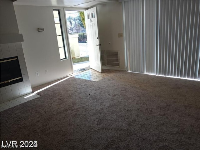 unfurnished living room featuring light colored carpet and a fireplace