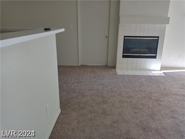 unfurnished living room with a tile fireplace and carpet flooring