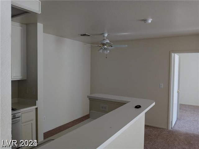 kitchen with white cabinetry, ceiling fan, light carpet, and stove