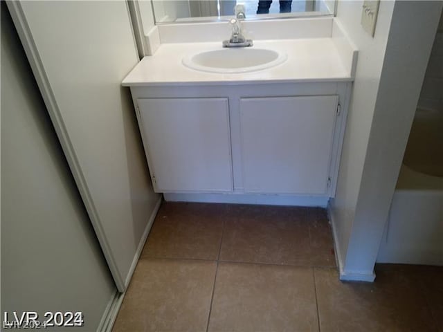 bathroom featuring tile patterned flooring, vanity, and a bath