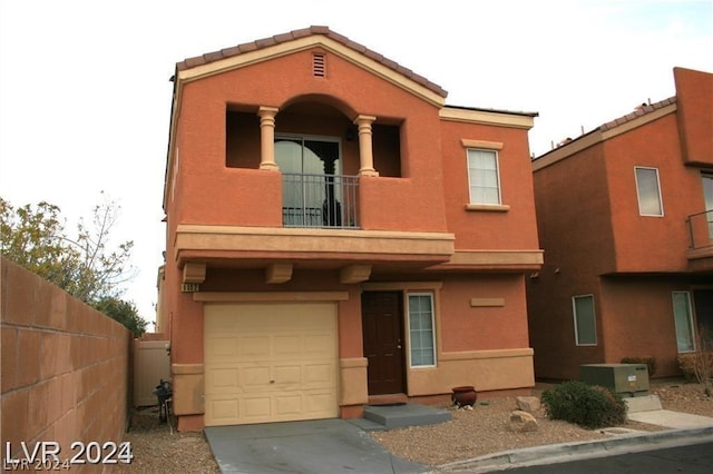 view of front of home featuring a balcony, a garage, and central AC unit