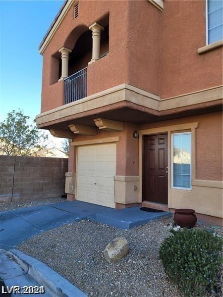 doorway to property featuring a garage and a balcony