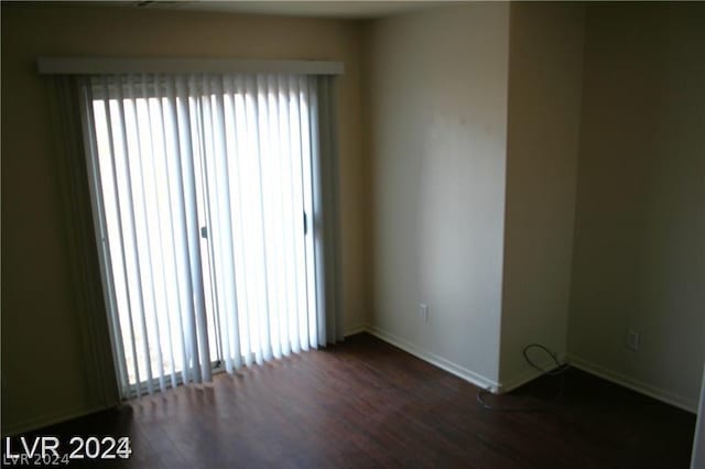 unfurnished room featuring plenty of natural light and dark hardwood / wood-style floors