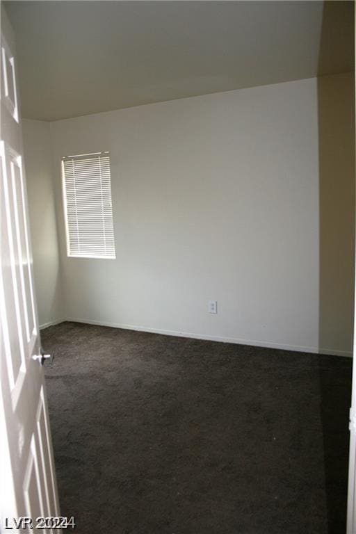 unfurnished room with dark colored carpet