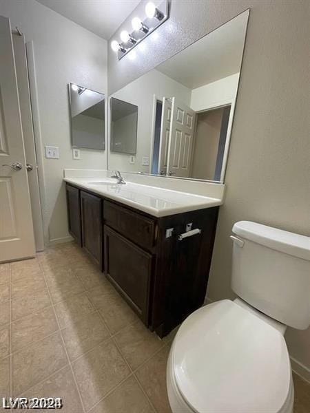 bathroom with vanity, tile patterned floors, and toilet